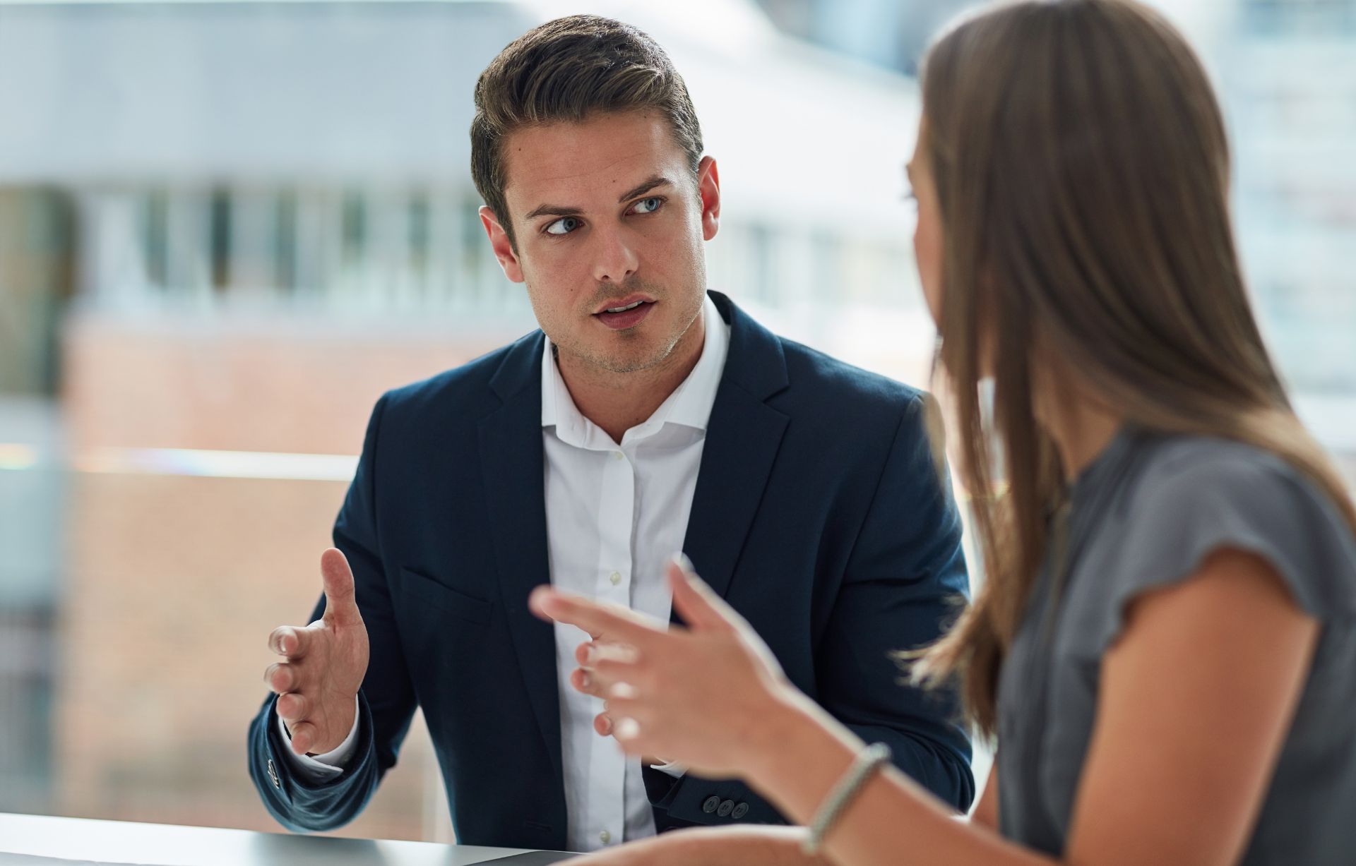 Man in een zakelijke omgeving, serieus in gesprek met een vrouw, mogelijk tijdens een professionele bespreking. Man in een zakelijke omgeving, serieus in gesprek met een vrouw, mogelijk tijdens een professionele bespreking.